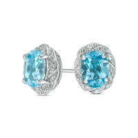 Oval Blue Topaz and 0.05 CT. T.W. Diamond Pinwheel Frame Stud Earrings in Sterling Silver