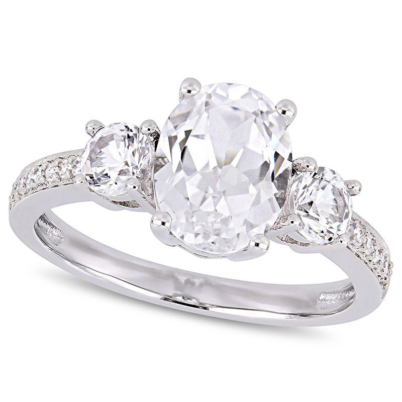 Oval Lab-Created White Sapphire and 0.07 CT. T.W. Diamond Three Stone Engagement Ring in Solid 10K White Gold