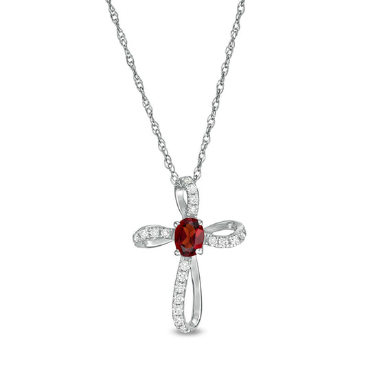 Oval Garnet and 0.1 CT. T.W. Natural Diamond Pinwheel Cross Pendant in 10K White Gold