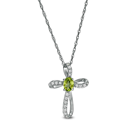 Oval Peridot and 0.1 CT. T.W. Natural Diamond Pinwheel Cross Pendant in 10K White Gold