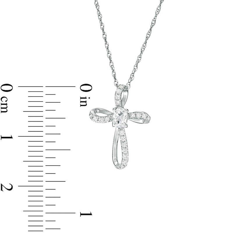 Oval White Topaz and 0.1 CT. T.W. Natural Diamond Pinwheel Cross Pendant in 10K White Gold